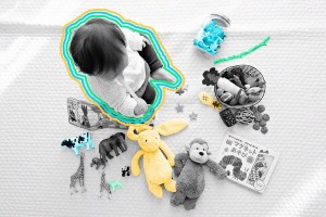 A small child surrounded by various toys including a stick, as seen from above