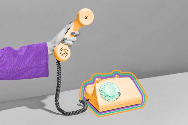 Manicured hand holding the receiver of a rotary phone