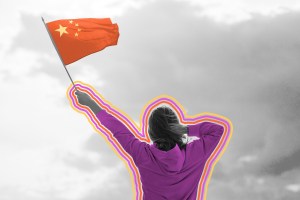 Woman waving the Flag of China against the blue sky