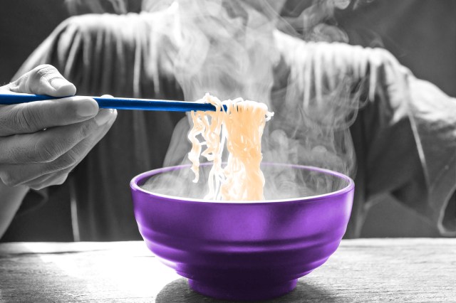 Man using chopsticks to lift ramen noodles out of a bowl