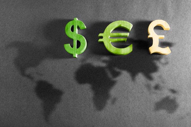 Money symbols above shadowy silhouettes of the continents