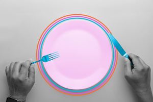 Top view image of a man holding fork and knife over an empty plate