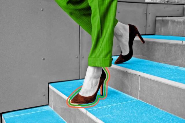 Close-up view of woman walking down the stairs in high heels