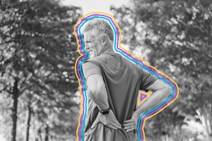 Older man wincing with his hands on his lower back