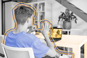 Over-the-shoulder view of teenage boy signing with his parents over video chat
