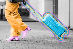 Traveler walking with wheeled suitcase outdoors